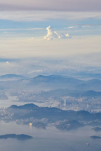 Aerial view of city by sea against sky