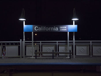 Text on structure and lighting equipment at railroad station platform