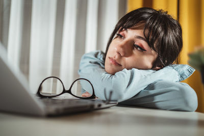 Frustrated young woman by laptop in office