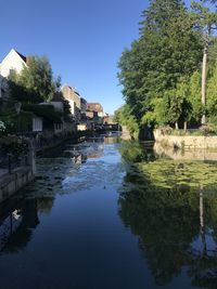 Scenic view of lake by buildings against sky