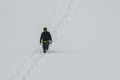 High angle view of man walking in deep snow