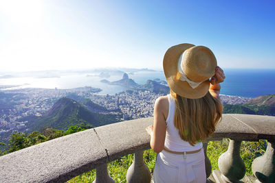 Traveler girl on corcovado mountain looks guanabara bay, rio de janeiro, brazil.