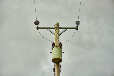 Low angle view of telephone pole against sky