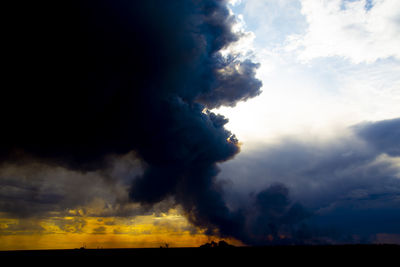 Smoke emitting from clouds against sky during sunset