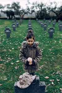 Portrait of boy holding camera on field