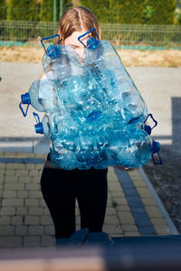 Midsection of woman holding blue umbrella