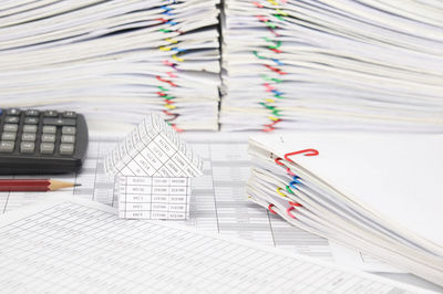 Close-up of model house and calculator on financial documents