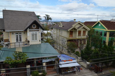 Houses in town against cloudy sky