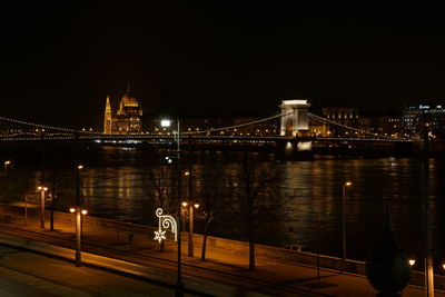 Illuminated bridge over river at night