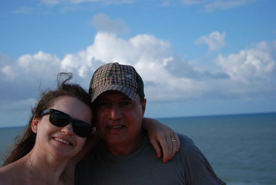 Portrait of smiling young woman in sea against sky