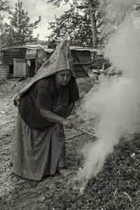 Portrait of young woman standing by smoke