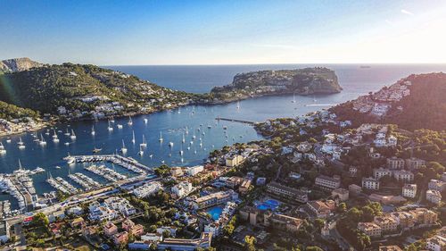 High angle view of townscape by sea against sky