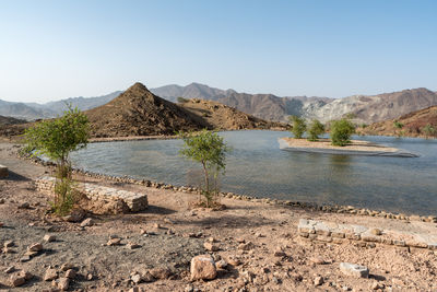 Scenic view of land and mountains against clear sky