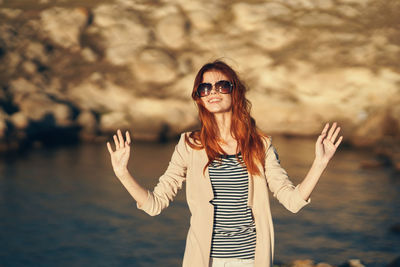 Portrait of young woman wearing sunglasses standing outdoors