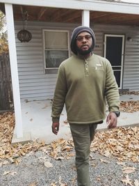 Portrait of man standing outside house