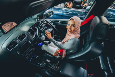 Portrait of female driver sitting in car