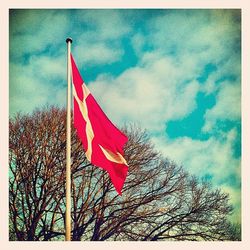 Low angle view of flags against cloudy sky