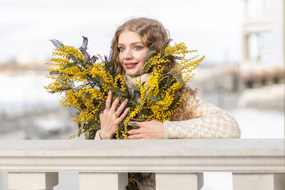 A woman  with a bouquet of yellow acacia flowers.the concept of the- march 8, easter, women's day.