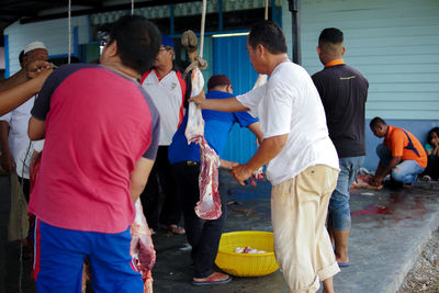 Rear view of people working on street in city