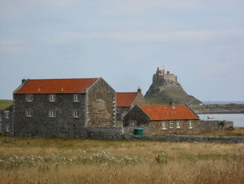 Old house on field against sky