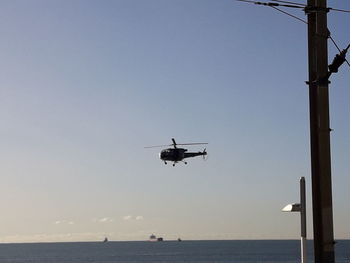 Airplane flying over sea against clear sky