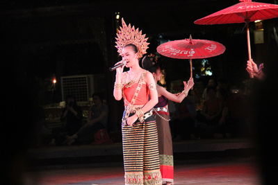 Woman holding umbrella at night