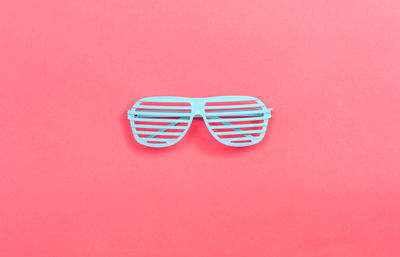 Directly above shot of sunglasses against pink background