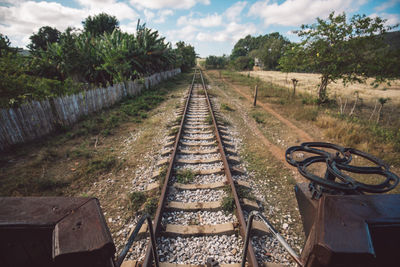 Railroad tracks on field against sky