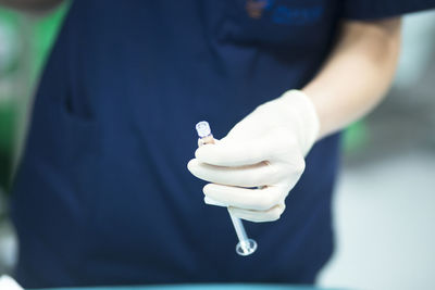 Midsection of doctor holding syringe