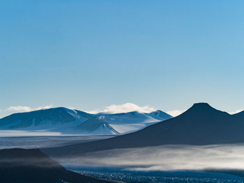 Scenic view of snowcapped mountains against blue sky