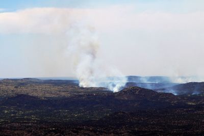 Smoke emitting from volcanic mountain against sky