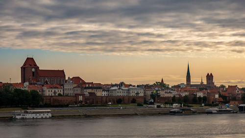 Buildings in city against cloudy sky