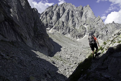 People walking on rocks against mountains