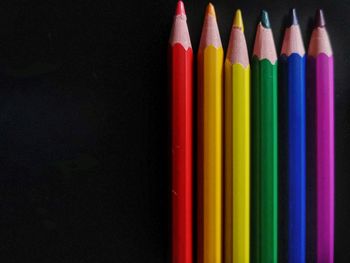High angle view of colored pencils against black background