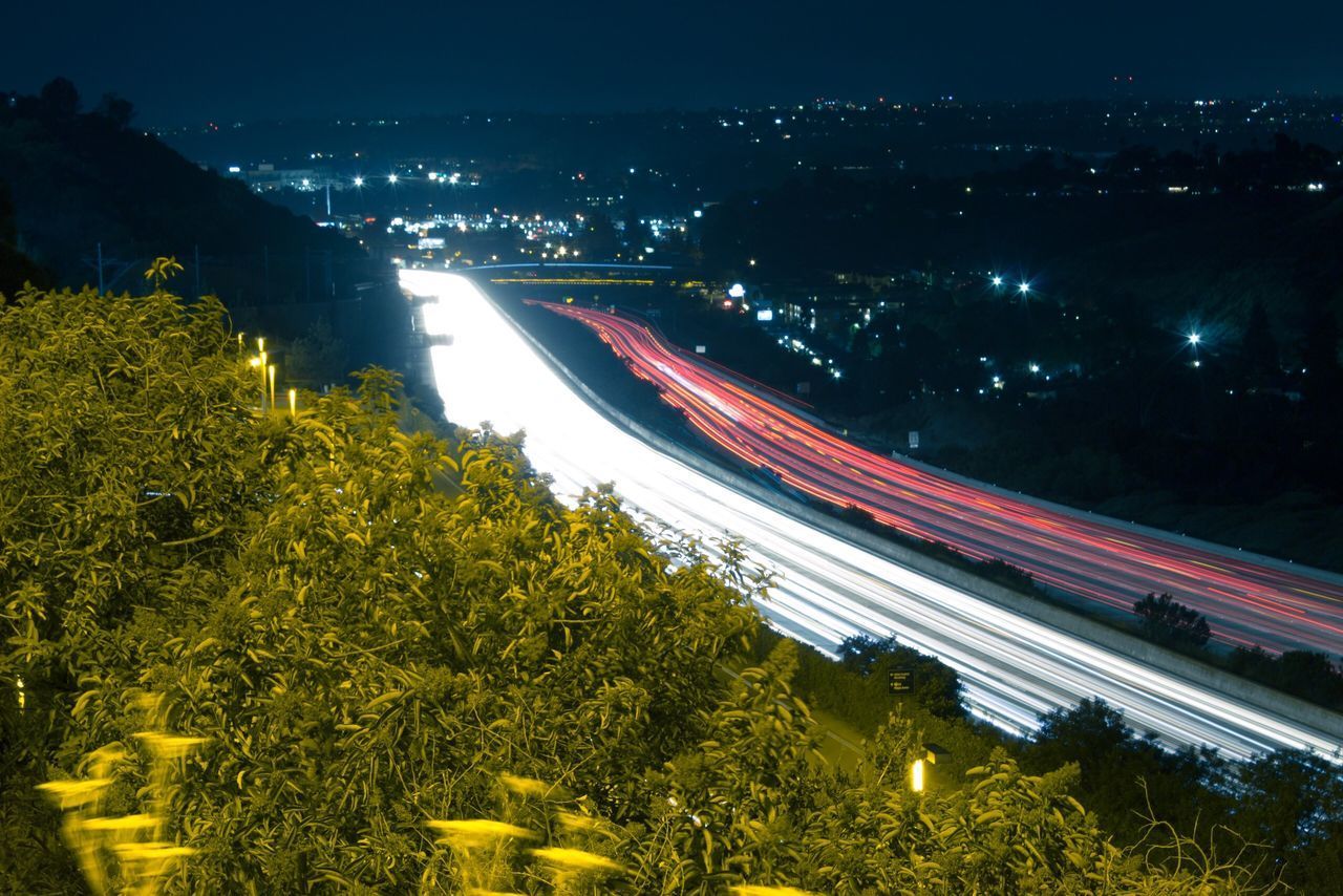 HIGH ANGLE VIEW OF LIGHT TRAILS AT NIGHT