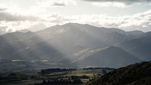 Beautiful landscape with green pastures and big mountain lit by warm late evening light, new zealand