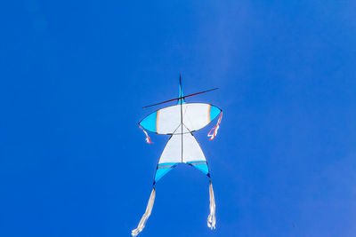 Low angle view of kite flying against clear blue sky