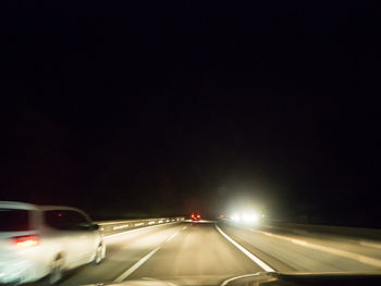 Cars on illuminated street at night