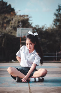Girl looking away while sitting outdoors