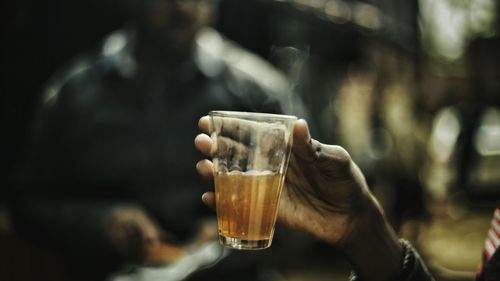 Cropped hand of man holding tea glass