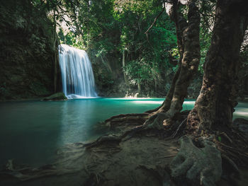 Epic waterfall smooth stream with emerald pond in rainforest. erawan falls, kanchanaburi, thailand.