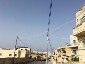 Cars on street in town against clear sky