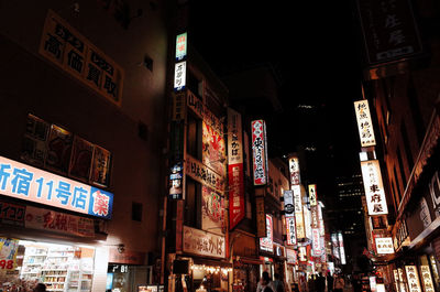 Low angle view of illuminated information sign at night