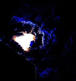 Low angle view of illuminated lights against dark sky