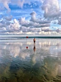 Men on beach against sky