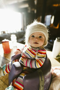 Portrait of cute baby girl sitting on potty at home