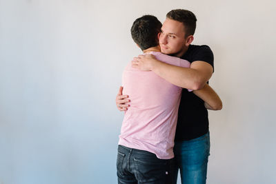 Two gay man hugging each other.