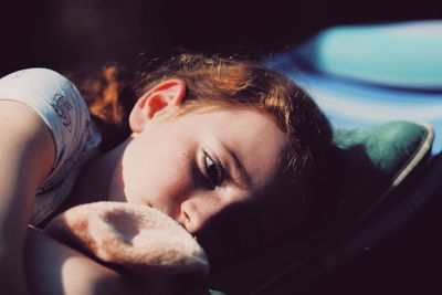 Close-up portrait of young woman lying down