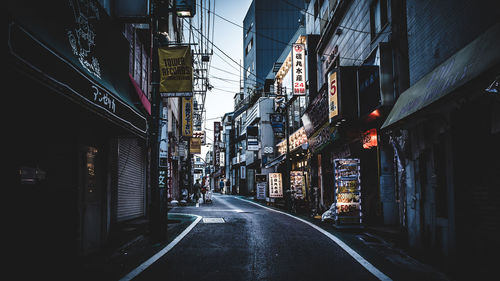 Empty city street amidst buildings