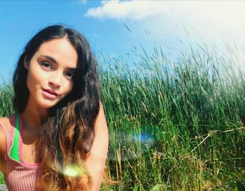 Portrait of smiling young woman against plants